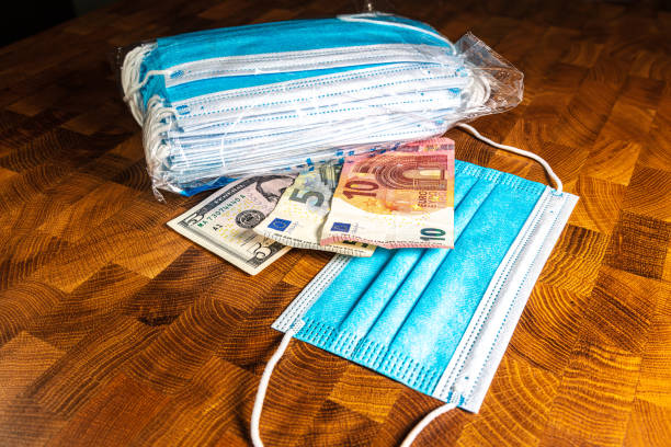 istock Face mask and banknotes on a wooden table 1276897125