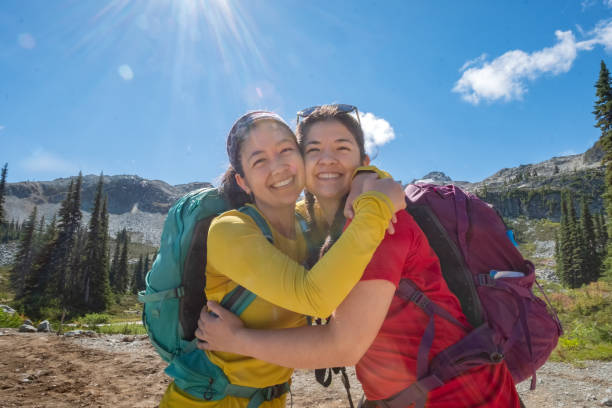 istock Multi-Ethnic Sisters Hiking and Hugging in Alpine Mountain Park 1276899750