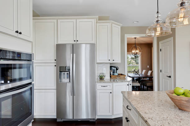 French door refrigerator in new kitchen Granite countertops in kitchen with beautiful pendant lights over the island appliance stock pictures, royalty-free photos & images