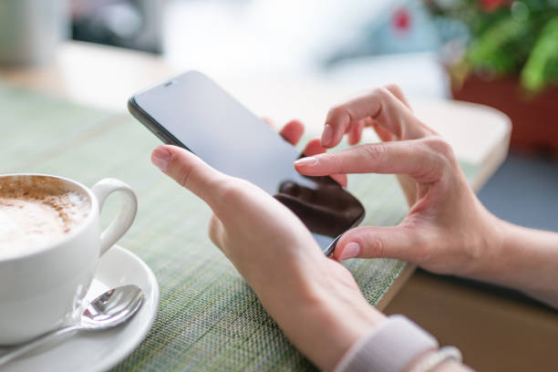 istock Woman uses smartphone at cafe 1276905517