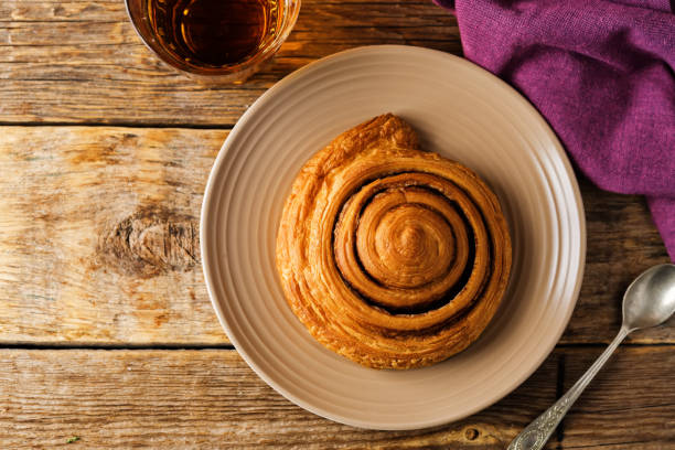 istock Cinnamon roll cake in a plate on a wooden background 1276907514