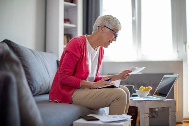 istock Senior mature woman counting bills at home. 1276908426