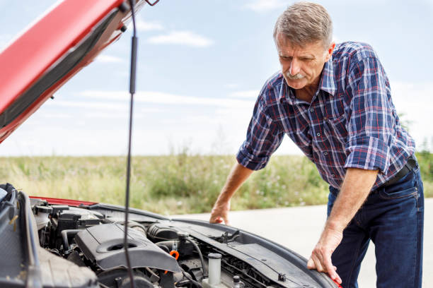 istock Displeased man looking under car hood 1276909333