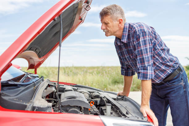 istock Man looking under the hood in order to fix his car 1276909335