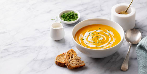 Pumpkin soup with cream. Marble background. Copy space.