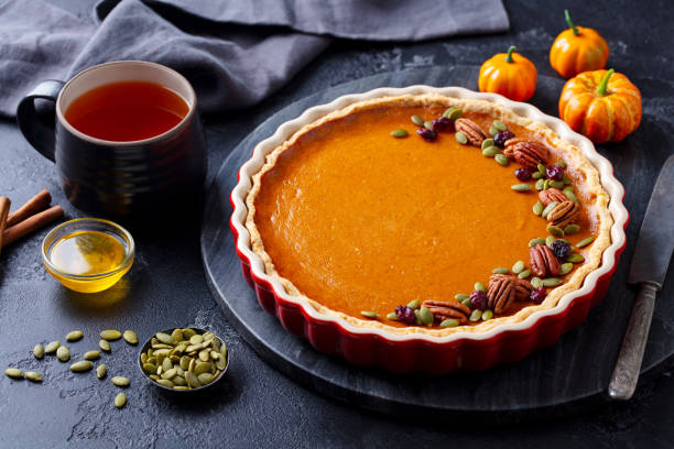 istock Pumpkin pie on marble board with cup of tea. Grey background. Close up. 1276909614