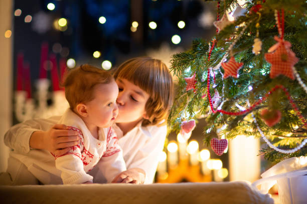 istock Child at Christmas tree. Kids at fireplace on Xmas 1276910310