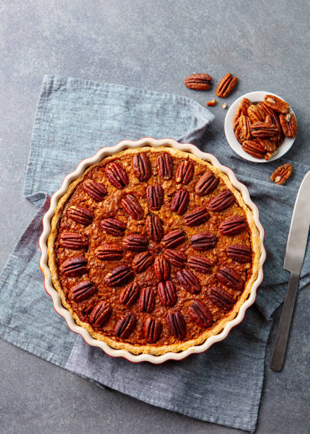 istock Pecan nut pie, tart in baking dish. Grey background. Top view. 1276910311
