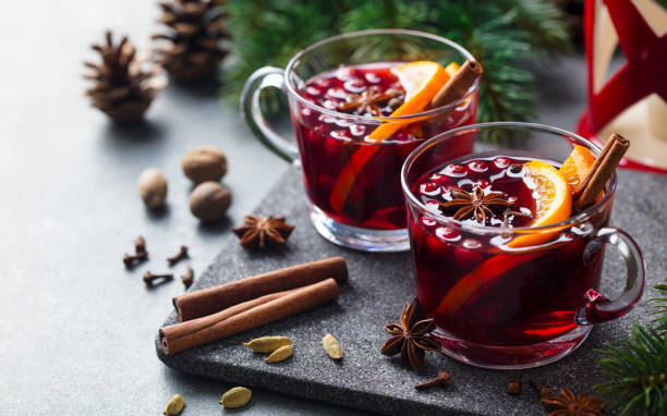 Mulled red wine with spices. Christmas decoration. Grey stone background. Close up. stock photo