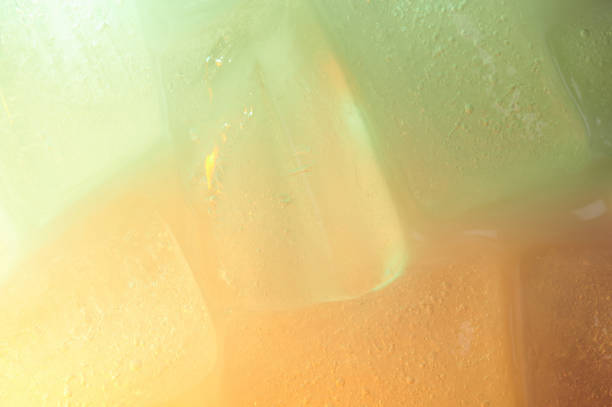 Surface of green and orange ice cubes macro close up view