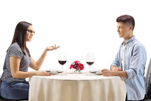 istock Teenagers sitting at a restaurant table and talking 1276914580