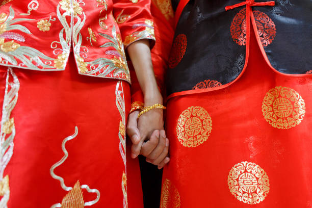 sección media de los novios chinos sosteniendo la mano - típico oriental fotografías e imágenes de stock