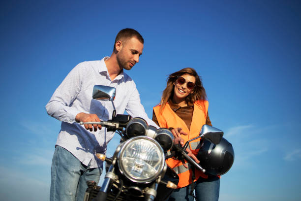 istock Driving instructor showing motorcycle commands and dashboard to the inexperienced student. Learning to ride motorcycle. 1276917680