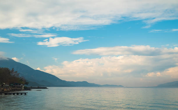 Seascape in cloudy weather. Silhouette of blue sky and mountains in background