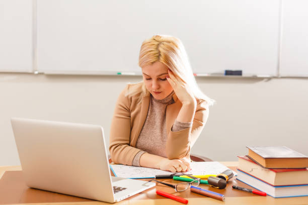 istock tired young teacher and classic chalkboard background 1276920437