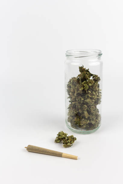 istock View of a glass jar with marijuana buds inside and a bud with a joint on a white background 1276920535