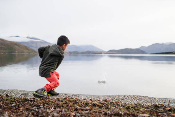 istock Kid skipping stones in lake. 1276921845