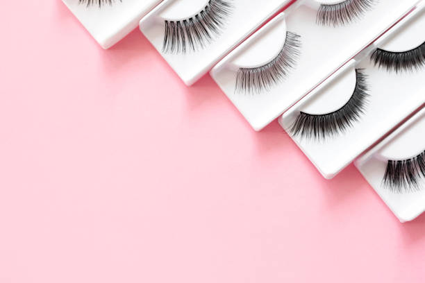 istock Different false eyelashes on a trendy pastel pink background. Beauty pattern. Makeup accessories. Cosmetics products for women. Top view, flat lay. Place for text. Layout. Сloseup. Copy space. 1276924707