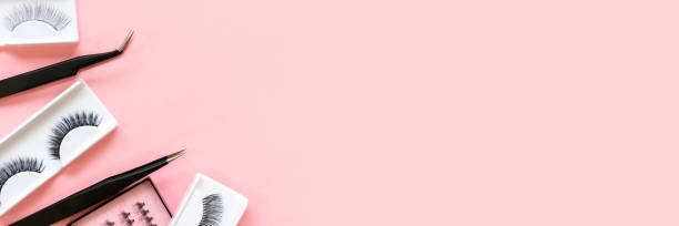 istock Different tools for eye lash extension on trendy pastel pink background. Fake eyelashes and tweezers. Beauty concept. Makeup cosmetics. Top view, flat lay. Layout. Place for text and design. Banner. 1276924712