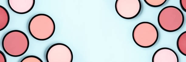 istock Pink blush and compact powder on a pastel blue background. Banner. Place for text, design. Top view.  Trending colors. Makeup. Cosmetic products. Tonal foundation. Flat lay, Layout. Beauty concept. 1276924719