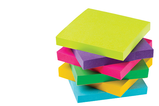 Close up view of colorful post it note isolated on white background.
