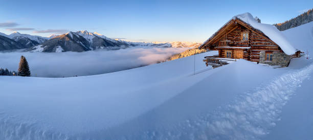 Snow covered mountain hut old farmhouse in the ski region of Saalbach Hinterglemm in the Austrian alps at sunrise Snow covered mountain hut old farmhouse in the ski region of Saalbach Hinterglemm in the Austrian alps at sunrise against blue sky chalet stock pictures, royalty-free photos & images
