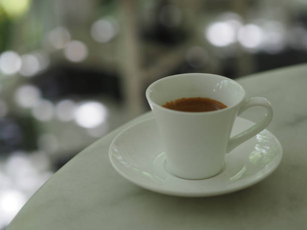 istock Espresso hot coffee in a white cup placed on marble table 1276928305