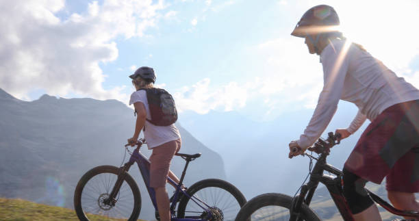 istock Female mountain e-bikers rides through alpine meadow 1276929562