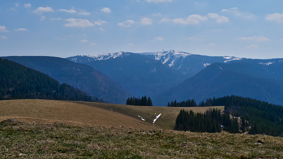 Panorama view of snow-capped Feldberg (1,493 m), the largest peak of low mountain range Black Forest, Baden-Wuerttemberg, Germany from the top of adjacent hill Belchen.