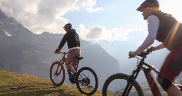 istock Female mountain e-bikers rides through alpine meadow 1276929620