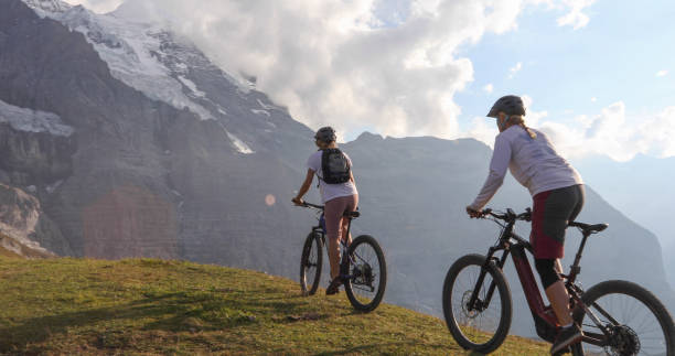 istock Female mountain e-bikers rides through alpine meadow 1276929659