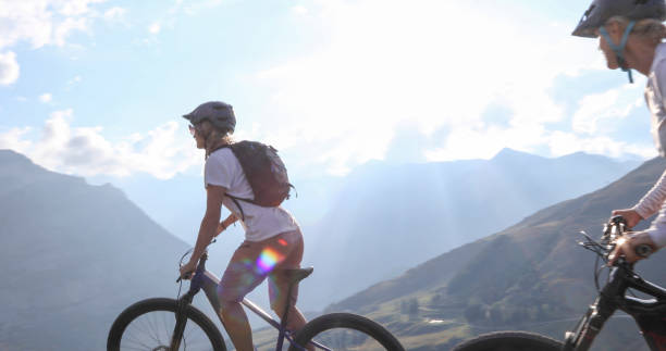 istock Female mountain e-bikers rides through alpine meadow 1276929671