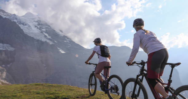 istock Female mountain e-bikers rides through alpine meadow 1276929674
