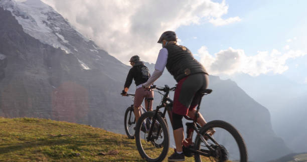 istock Female mountain e-bikers rides through alpine meadow 1276929690