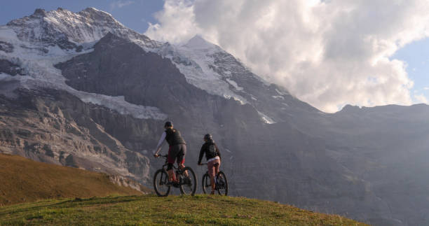 istock Female mountain e-bikers rides through alpine meadow 1276930205