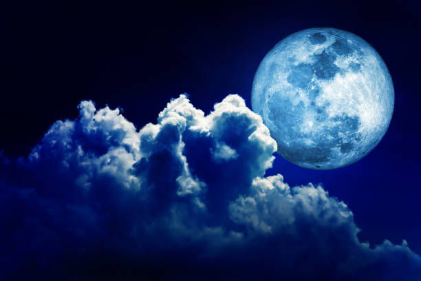 istock Full moon in blue lighting night sky background with clouds. 1276931661