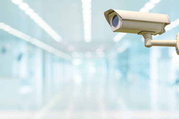 istock Used Closed Circuit Television Camera or Security CCTV camera with blurry image of walking way inside shopping mall. 1276931837