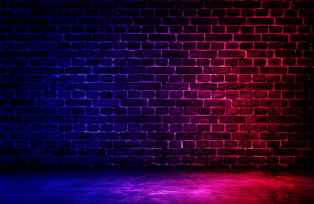 istock Studio dark room black brick wall with red and blue lighting effect. 1276932704