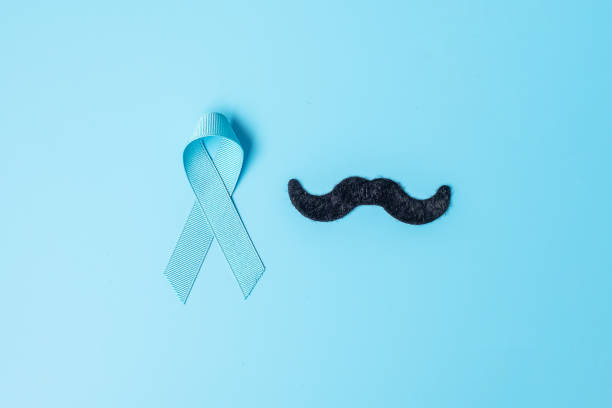November Prostate Cancer Awareness month, light Blue Ribbon with mustache on wooden background for supporting people living and illness. Farther, international men day and World cancer day concept noviembre mes de concientización sobre el cáncer de próstata, cinta azul ligera con bigote sobre fondo de madera para apoyar a las personas que viven y enferman. más lejos, día internacional de los hombres y concepto del día mundial del cáncer