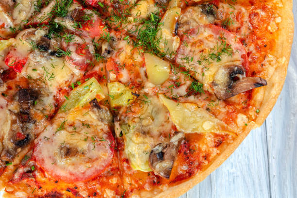 istock pizza with cheese vegetables and meat on a wooden background 1276935159