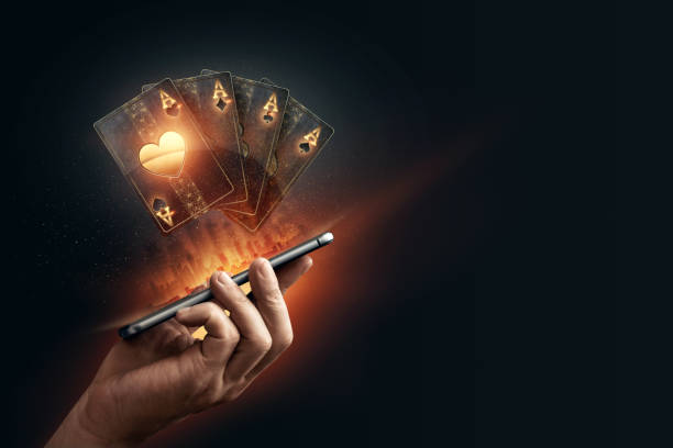 en las manos de un teléfono inteligente con cartas de juego, fondo de oro negro. concepto de juegos de azar en línea, casino en línea. copiar espacio. - blackjack cards casino gambling fotografías e imágenes de stock