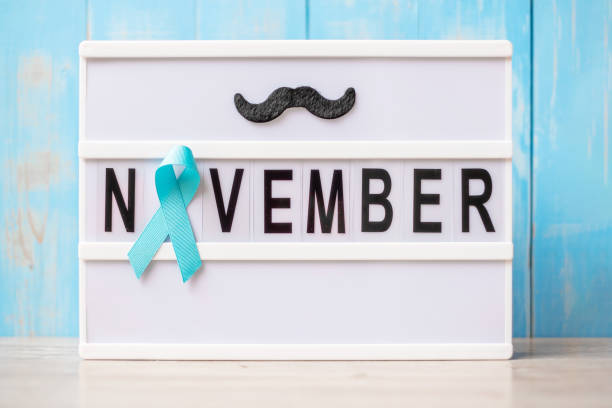 Prostate Cancer Awareness month, Light blue Ribbon with mustache on lightbox with November text background for supporting people living and illness. International Men day and World cancer day concept mes de concientización sobre el cáncer de próstata, cinta azul claro con bigote en la caja de luz con fondo de texto de noviembre para apoyar a las personas que viven y enferman. día internacional del hombre y concepto del día mundial del cáncer