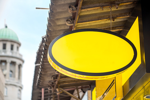 Blank oval yellow signboard on the wall outdoor mockup