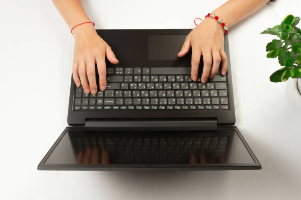 istock female hands are typing text on laptop keyboard on white table background 1276941886
