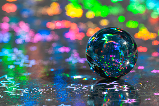 Closeup of abstract glass Christmas ball on glitter background.