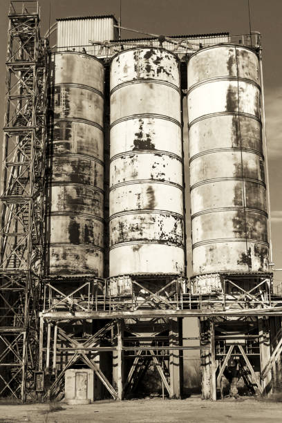 istock Old, abandoned concrete plant with iron rusty tanks and metal structures. The crisis, the fall of the economy, stop production capacity led to the collapse. Global catastrophe. Old photo effect. 1276944086