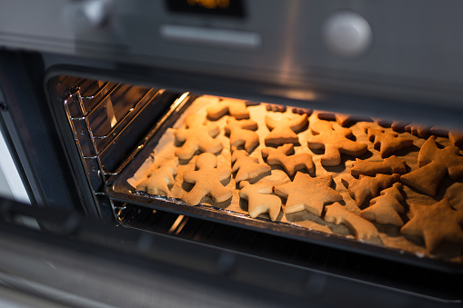 bakery and cooking - close up of cookies or gingerbreads in oven