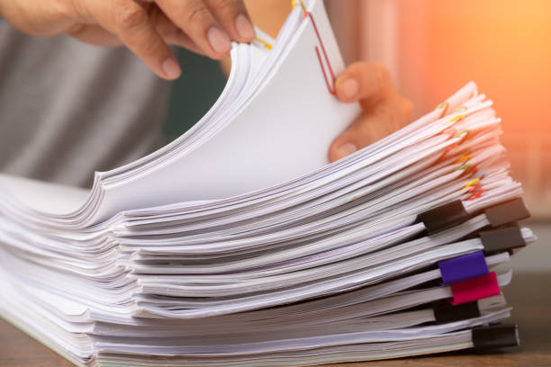 istock Business man hand pick up Stack overload document report paper with colorful paperclip, business and paperless concept. 1276949547