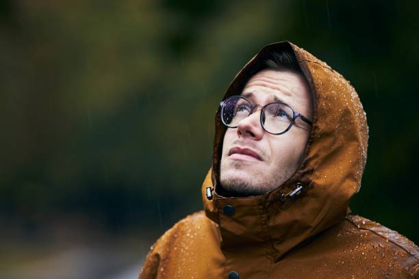 man in waterproof jacket during rain - rain drenched men wet imagens e fotografias de stock