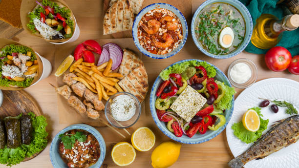Assorted dishes of Greek Cuisine on table. souvlaki with chicken and french fries, Greek salad with feta, , giros with chicken, Greek soup and dolma, top view on wooden table Assorted dishes of Greek Cuisine on table. souvlaki with chicken and french fries, Greek salad with feta, giros with chicken, Greek soup and dolma, top view on wooden table shawarma kebab chicken souvlaki stock pictures, royalty-free photos & images